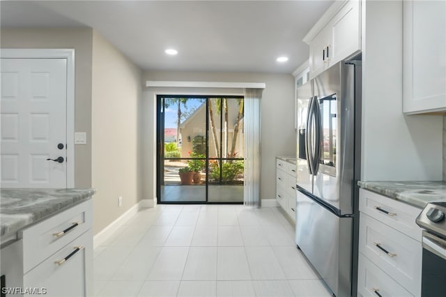 kitchen with light stone countertops, white cabinetry, stainless steel refrigerator with ice dispenser, and light tile flooring