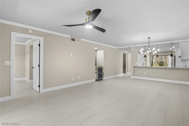 unfurnished living room with light tile flooring, wine cooler, ornamental molding, and ceiling fan with notable chandelier