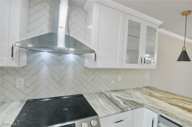 kitchen with pendant lighting, tasteful backsplash, ornamental molding, and wall chimney range hood