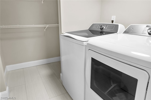 laundry room featuring light tile floors and washing machine and clothes dryer