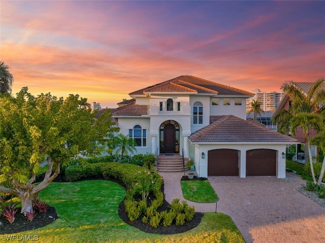 mediterranean / spanish-style home with a lawn and a garage