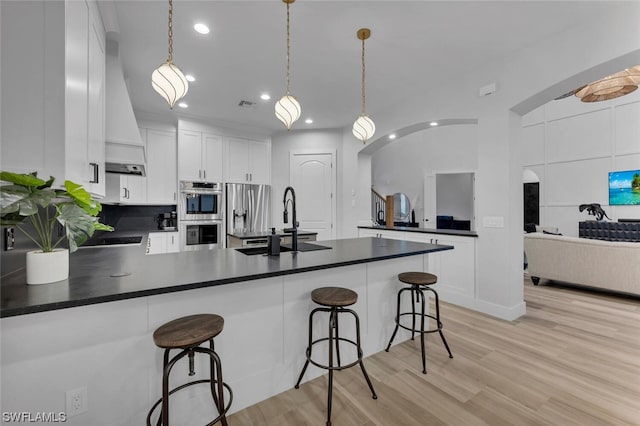 kitchen featuring white cabinetry, light hardwood / wood-style flooring, and hanging light fixtures