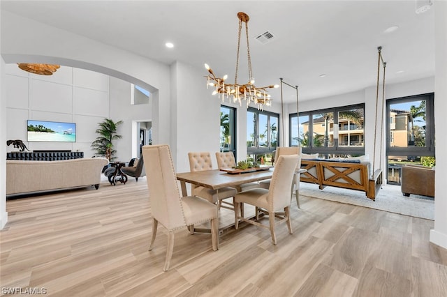 dining space with an inviting chandelier and light wood-type flooring