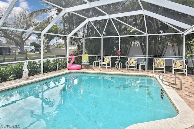 view of pool featuring glass enclosure and a patio area