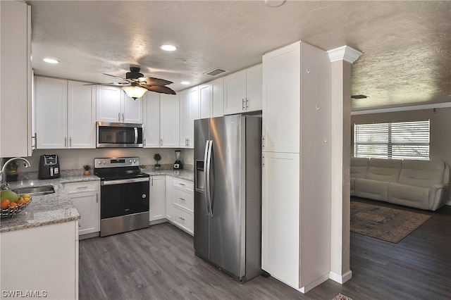 kitchen with white cabinets, sink, appliances with stainless steel finishes, and dark wood-type flooring