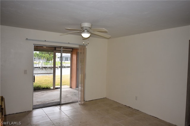 tiled empty room with a water view and ceiling fan