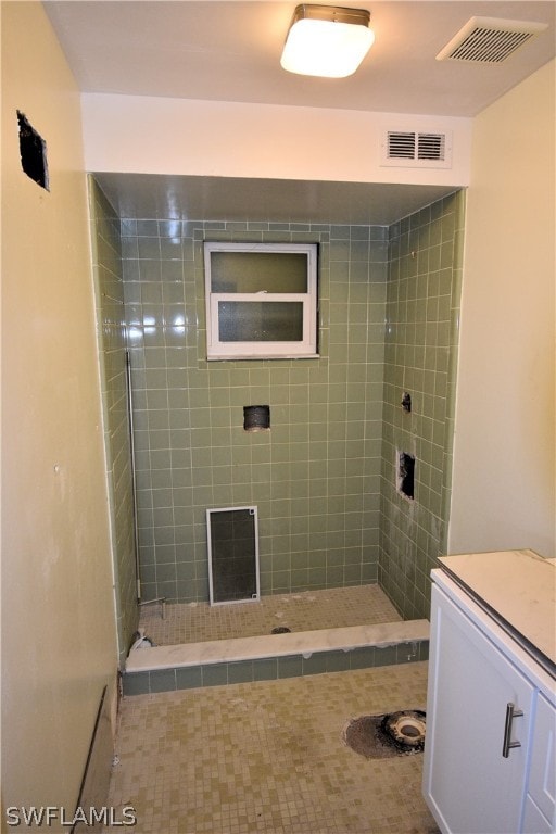 bathroom featuring a tile shower and vanity