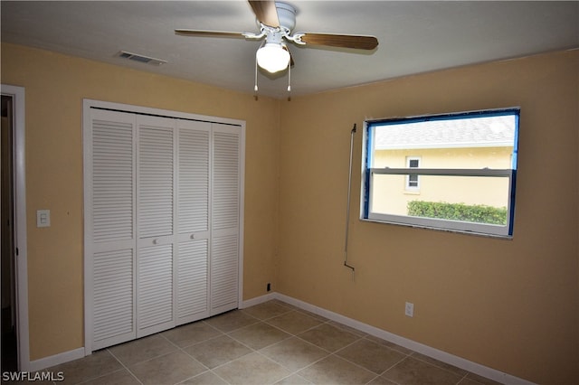 unfurnished bedroom with a closet, ceiling fan, and light tile patterned flooring