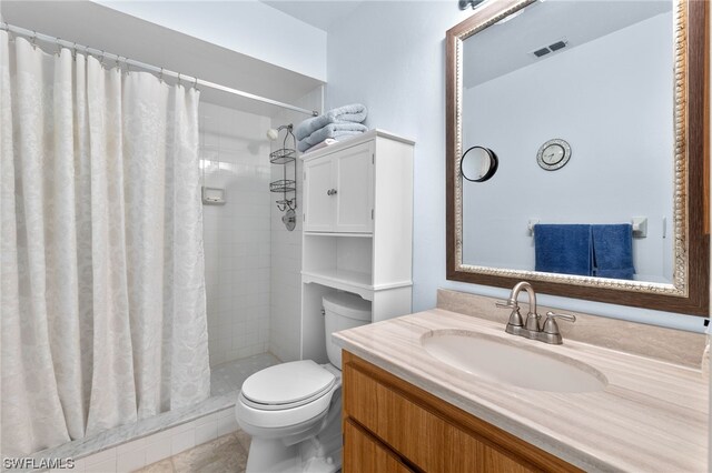 bathroom with toilet, vanity, tile patterned floors, and a shower with curtain