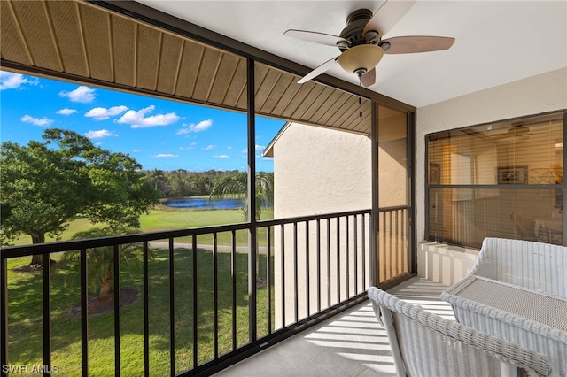 balcony with ceiling fan and a water view