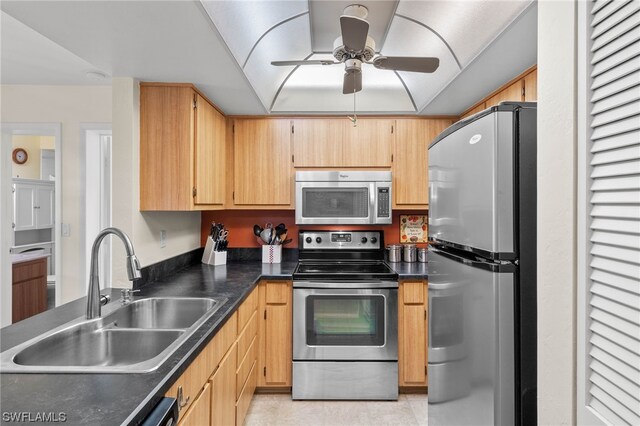 kitchen featuring stainless steel appliances, light brown cabinets, sink, and ceiling fan