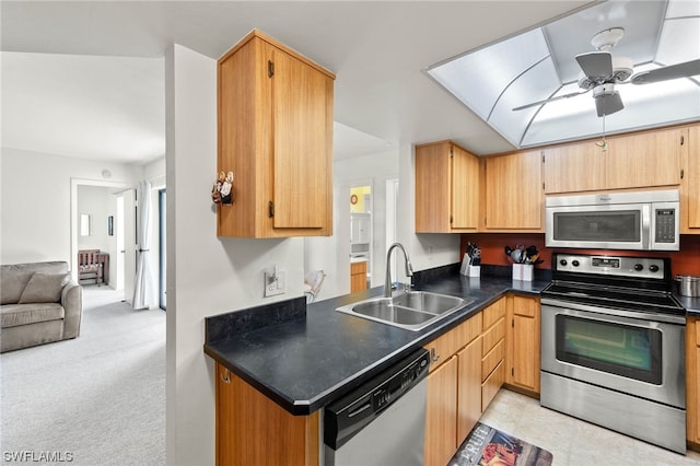 kitchen with sink, stainless steel appliances, light colored carpet, and ceiling fan