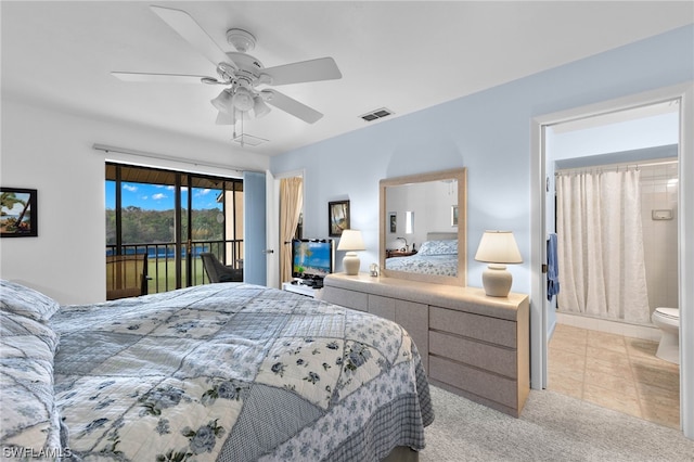 bedroom featuring access to outside, ensuite bath, light colored carpet, and ceiling fan