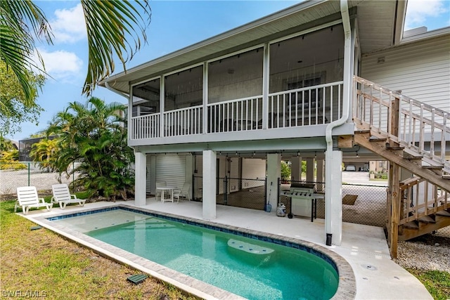 832 Swan Dr, Marco Island, FL 34145 - back of house featuring a sunroom, fence, stairway, a patio, and an outdoor pool