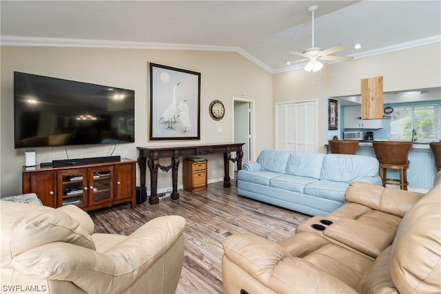 living room featuring dark wood-type flooring, ceiling fan, sink, vaulted ceiling, and crown molding