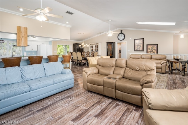 living room with sink, crown molding, a skylight, ceiling fan with notable chandelier, and hardwood / wood-style flooring