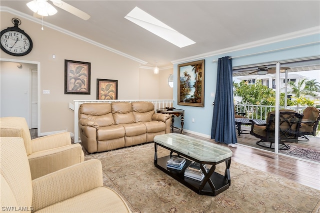 living room featuring vaulted ceiling with skylight, ornamental molding, ceiling fan, and light hardwood / wood-style flooring