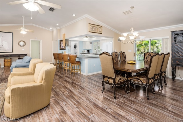 dining room featuring crown molding, hardwood / wood-style floors, ceiling fan with notable chandelier, and lofted ceiling