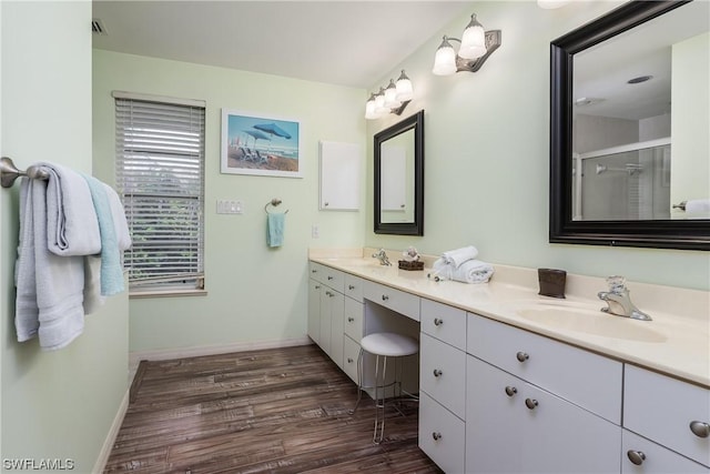 832 Swan Dr, Marco Island, FL 34145 - bathroom featuring double vanity, a sink, a stall shower, and wood finished floors