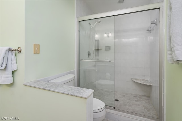 bathroom with toilet and a shower with shower door