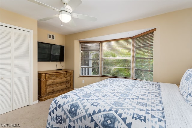 bedroom with a closet, ceiling fan, and light colored carpet