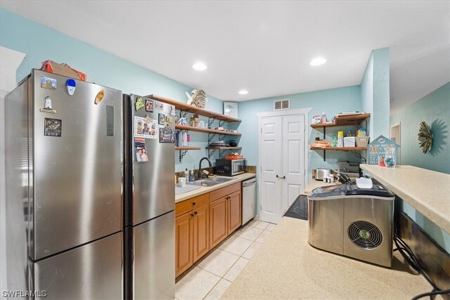 kitchen featuring light tile floors, sink, and stainless steel appliances