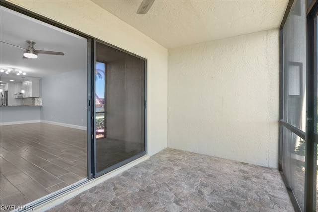 unfurnished sunroom featuring ceiling fan