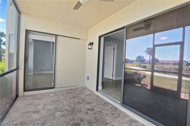 unfurnished sunroom featuring ceiling fan