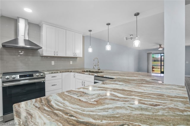 kitchen with kitchen peninsula, backsplash, sink, stainless steel appliances, and wall chimney range hood