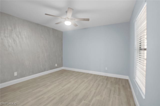 unfurnished room featuring a healthy amount of sunlight, ceiling fan, and light hardwood / wood-style flooring