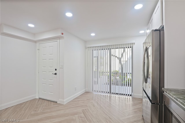 kitchen featuring white cabinets, light parquet floors, and stainless steel refrigerator