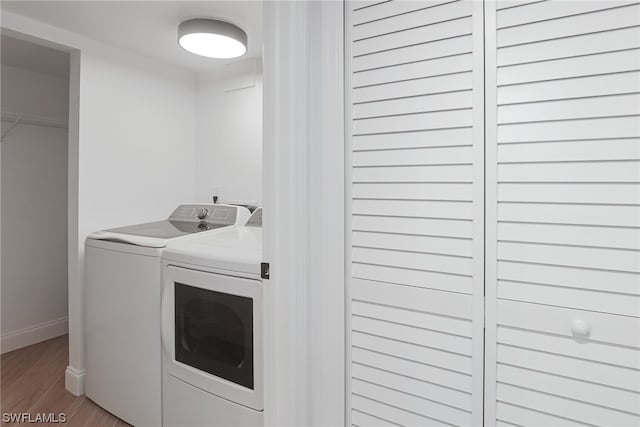 clothes washing area featuring hardwood / wood-style floors and washing machine and clothes dryer