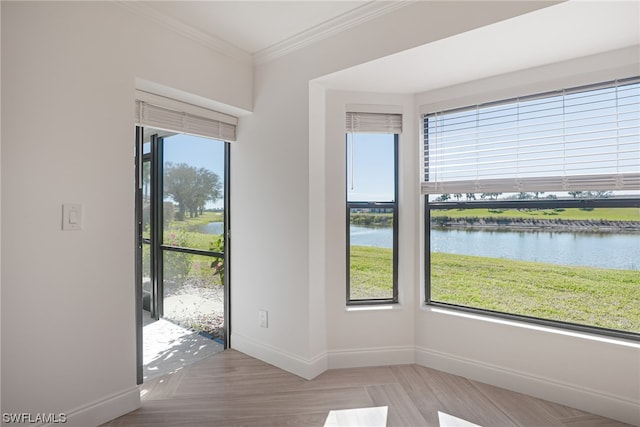 interior space with light parquet flooring, a water view, and ornamental molding