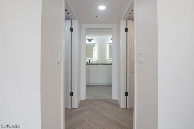 corridor featuring sink and light wood-type flooring