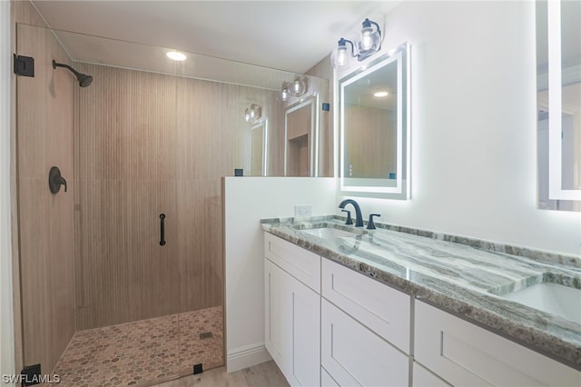 bathroom featuring dual bowl vanity and a tile shower