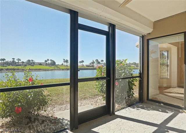 sunroom / solarium featuring a water view