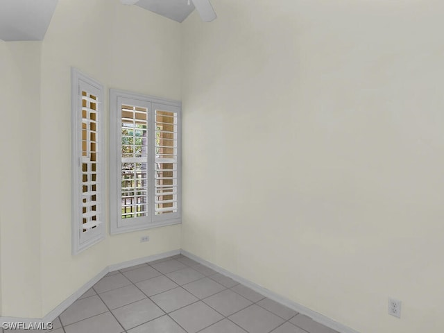 tiled spare room featuring ceiling fan