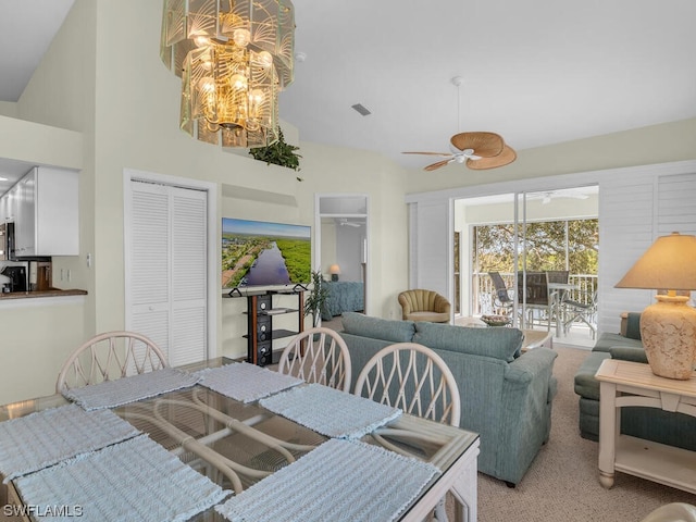 dining room with high vaulted ceiling, ceiling fan, and light carpet