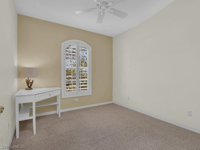 carpeted spare room featuring ceiling fan