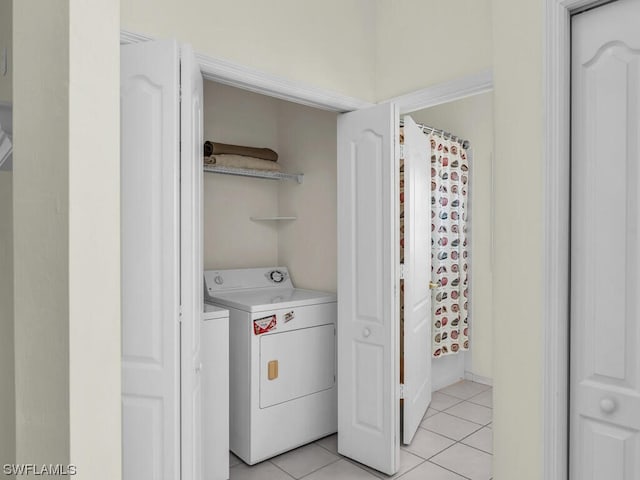 laundry area featuring light tile flooring and washer and clothes dryer