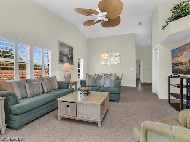 carpeted living room with ceiling fan with notable chandelier and lofted ceiling