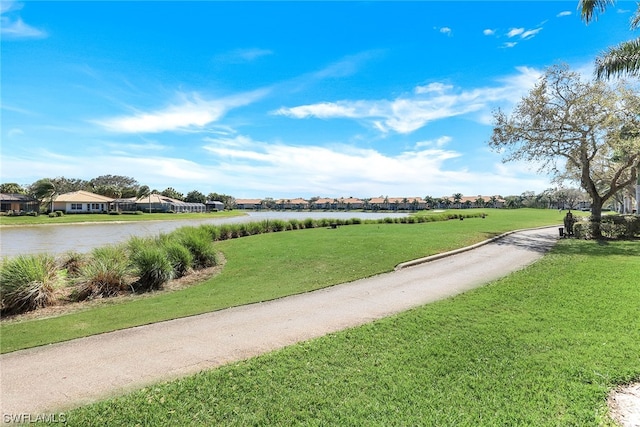 view of property's community featuring a water view and a yard