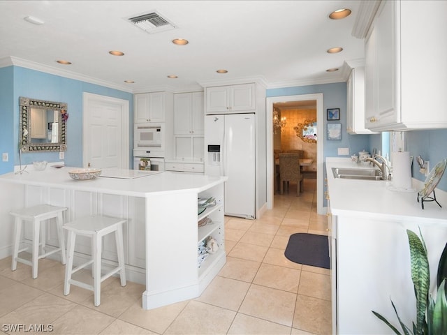 kitchen featuring white cabinets, light tile floors, white appliances, and sink