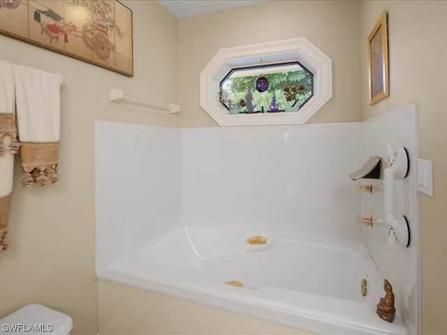 bathroom with toilet and a bath