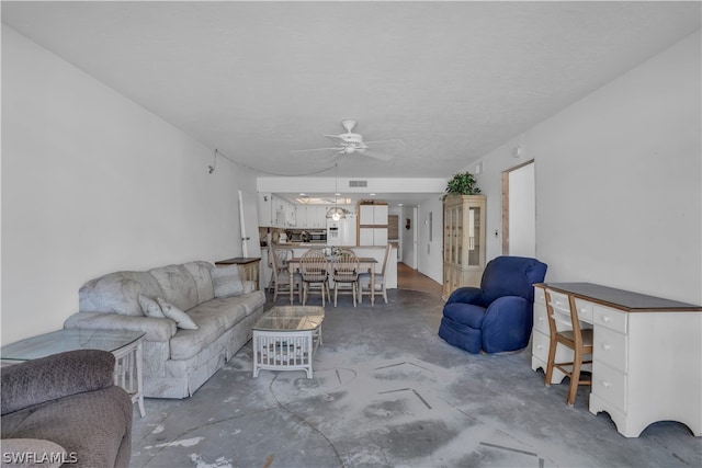 living room featuring ceiling fan and concrete flooring