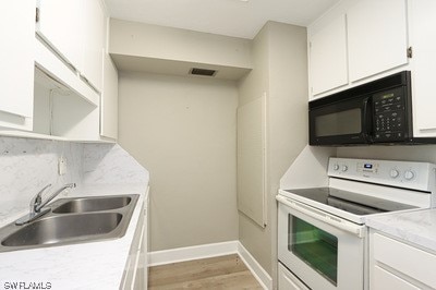 kitchen with sink, white cabinets, white range, and light hardwood / wood-style flooring