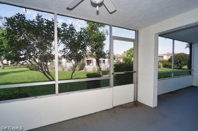 unfurnished sunroom with ceiling fan