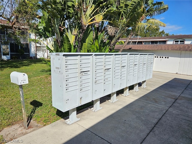 view of property's community with mail boxes and a yard