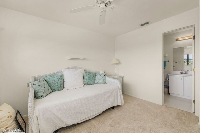 carpeted bedroom featuring ensuite bath and ceiling fan