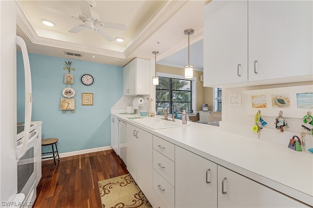 kitchen featuring hanging light fixtures, ceiling fan, white cabinetry, a tray ceiling, and sink